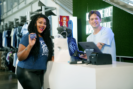 Image of a man paying with a Sporting KC debit card